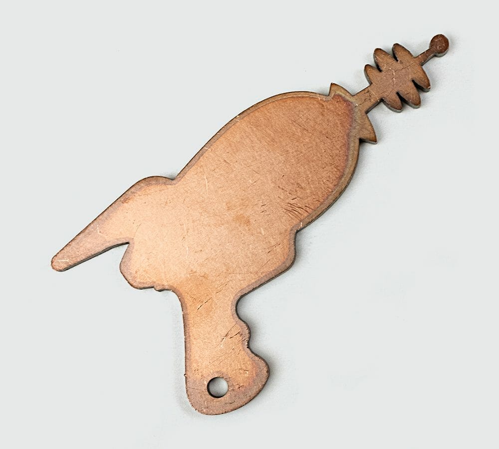 Image of laser cut copper laser gun on a white background